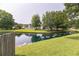 Picturesque view of the pond surrounded by mature trees and lush greenery, reflecting neighborhood homes at 3290 Middleburry Ln, Charleston, SC 29414