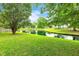 Scenic pond surrounded by vibrant green grass, mature trees and serene water, creating a peaceful landscape at 3290 Middleburry Ln, Charleston, SC 29414