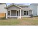 Back view showcasing a covered patio area with white columns and a spacious lawn at 327 Hillman Trl Dr, Moncks Corner, SC 29461