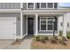 Close-up of a home's entrance featuring a black door, white trim, and manicured landscaping at 327 Hillman Trl Dr, Moncks Corner, SC 29461