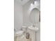 Cozy half-bathroom features a pedestal sink, round mirror, and efficient toilet at 3706 Blackjack Rd, Ladson, SC 29456
