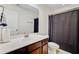 Bright bathroom featuring wood cabinets, white countertops, and a bathtub with a dark shower curtain at 3706 Blackjack Rd, Ladson, SC 29456