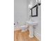 Charming half bathroom with hardwood floors, patterned wallpaper, and a pedestal sink at 400 Bay Crossing Rd, Mount Pleasant, SC 29464
