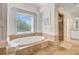 Luxurious bathroom showcasing soaking tub with jets, decorative columns, and natural light at 400 Bay Crossing Rd, Mount Pleasant, SC 29464