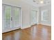 Sunny bedroom with hardwood floors, ceiling fan, and double doors leading to a balcony at 400 Bay Crossing Rd, Mount Pleasant, SC 29464
