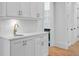 Close-up of a wet bar with white cabinets, gold hardware, and quartz countertops at 400 Bay Crossing Rd, Mount Pleasant, SC 29464