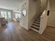 Open-concept living room and staircase feature hardwood floors, shutters, and a neutral color palette at 4013 Conant Rd, Mount Pleasant, SC 29466