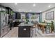 Spacious kitchen featuring dark cabinetry, stainless steel appliances, and a dining area with natural light at 409 Grand Palm Ln, Summerville, SC 29485