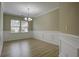 Bright, empty dining room with wainscoting, chandelier and large window at 484 Whispering Breeze Ln, Summerville, SC 29486