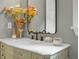 Bathroom detail of the marble vanity with gold fixtures, decorative mirror, and flower arrangement at 49 Crosscreek Dr, Charleston, SC 29412