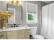 Bathroom featuring a marble vanity with a rectangular mirror and white toilet with pleated blinds on the window at 49 Crosscreek Dr, Charleston, SC 29412