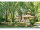 Charming two-story home featuring a wide front porch with white railings, brick accents, and mature landscaping at 49 Crosscreek Dr, Charleston, SC 29412