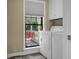 Convenient laundry area with washer, dryer, and a window with view to an outdoor porch swing at 49 Crosscreek Dr, Charleston, SC 29412