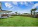Expansive backyard featuring lush green grass and a covered patio with outdoor seating at 603 Cavour Ct, Summerville, SC 29486