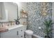 Stylish powder room featuring a decorative pebble accent wall, modern fixtures, and floating wooden shelves at 603 Cavour Ct, Summerville, SC 29486