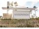 Community entrance sign for Woodwinds, set against a backdrop of trees and landscaping at 603 Cavour Ct, Summerville, SC 29486