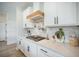 White cabinets and quartz countertops highlight this kitchen with stainless steel accents and a gas cooktop at 603 Cavour Ct, Summerville, SC 29486