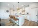 Well-lit kitchen features a center island with bar stool seating, white cabinetry and modern pendant lighting at 603 Cavour Ct, Summerville, SC 29486