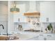 Modern kitchen featuring white cabinetry, elegant light fixtures, stainless steel range, and a designer range hood at 603 Cavour Ct, Summerville, SC 29486