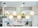 Modern kitchen lighting fixture with globe lights against a backdrop of white cabinets and tiled backsplash at 603 Cavour Ct, Summerville, SC 29486