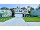 Two-story home featuring a two-car garage, gray brick accents, black shutters, with adjacent lawns at 619 Red Mulberry Rd, Moncks Corner, SC 29461