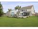 Expansive backyard with lush lawn, pool, patio with umbrella, screened porch, and tasteful landscaping at 626 Chigwell Springs Ln, Summerville, SC 29486