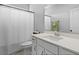 Bright bathroom showcasing a white vanity with a quartz countertop, a framed mirror, and a shower with white curtain at 626 Chigwell Springs Ln, Summerville, SC 29486