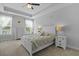 Serene bedroom with tray ceiling, carpet, and natural light streaming through the windows at 626 Chigwell Springs Ln, Summerville, SC 29486