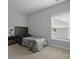 This is a cozy bedroom with neutral-colored walls, plush carpeting, and ample natural light from the window at 626 Chigwell Springs Ln, Summerville, SC 29486