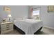 Bright bedroom with a comfortable bed, a side table lamp, and a view of the outdoors at 626 Chigwell Springs Ln, Summerville, SC 29486