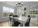Bright dining room with a modern chandelier, dark wood floors, and large windows offering ample natural light at 626 Chigwell Springs Ln, Summerville, SC 29486