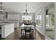 Bright dining room with modern chandelier, dark wood floors, and a view to the patio via sliding glass doors at 626 Chigwell Springs Ln, Summerville, SC 29486