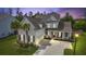 Charming two-story home featuring a well-maintained yard, palm trees, and inviting red front door at 626 Chigwell Springs Ln, Summerville, SC 29486