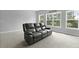 Relax in this spacious living room featuring comfortable leather seating and natural light from bright windows at 626 Chigwell Springs Ln, Summerville, SC 29486