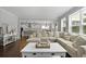 Bright and airy living room with a large sectional sofa, dark wood floors, and an open floor plan into the kitchen at 626 Chigwell Springs Ln, Summerville, SC 29486