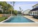Sparkling pool with a tranquil waterfall feature, complemented by palm trees and lush landscaping for a private oasis at 626 Chigwell Springs Ln, Summerville, SC 29486