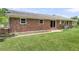 View of the brick exterior and manicured lawn from the backyard of the home at 6305 Lucille Dr, North Charleston, SC 29406