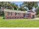 Beautiful brick home featuring a manicured lawn and classic design, blending comfort with charm at 6305 Lucille Dr, North Charleston, SC 29406