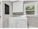 Bright laundry room featuring a washer, dryer, cabinets, and a window at 6305 Lucille Dr, North Charleston, SC 29406