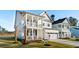 Beautiful two-story white house with a front porch, balcony, and well-manicured lawn at 735 Maynard Ln, Summerville, SC 29486