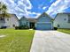 Charming blue home featuring manicured lawn and an attached two-car garage at 7629 High Maple Cir, North Charleston, SC 29418