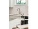 Close-up of a modern kitchen sink with white subway tile backsplash and neutral countertop at 770 Opal Wing St, Moncks Corner, SC 29461