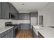 This contemporary kitchen is complete with stainless appliances, gray cabinetry and white countertops at 772 Opal Wing St, Moncks Corner, SC 29461