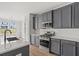 This modern kitchen features a peninsula island, gray cabinetry, stainless appliances, and white countertops at 772 Opal Wing St, Moncks Corner, SC 29461