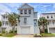 Charming light blue coastal home featuring white trim, garage, and palm trees at 779 Forrest Dr, Charleston, SC 29492
