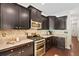Modern kitchen with stainless steel appliances, granite counters, and dark wood cabinets at 826 Bibury Ct, Charleston, SC 29414