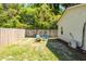 Backyard with wood fence, grassy area, patio lights, and outdoor seating with fire pit at 8562 N Highway 17, McClellanville, SC 29458