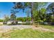 Large backyard with a storage shed, grassy areas, and a gravel parking pad at 8562 N Highway 17, McClellanville, SC 29458