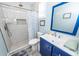 Bright bathroom features white marble-look tile, blue vanity, and walk-in shower at 8562 N Highway 17, McClellanville, SC 29458