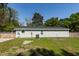 View of side of light green house, showcasing the roof, yard, fence, and AC unit at 8562 N Highway 17, McClellanville, SC 29458